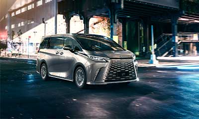 Front on view of a silver LM driving at nighttime.
