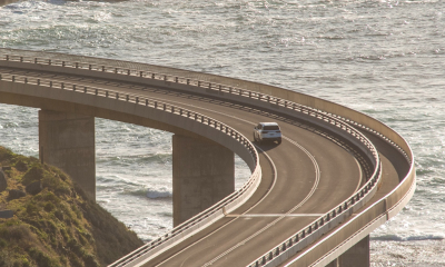 White LX drives across a coastal road.