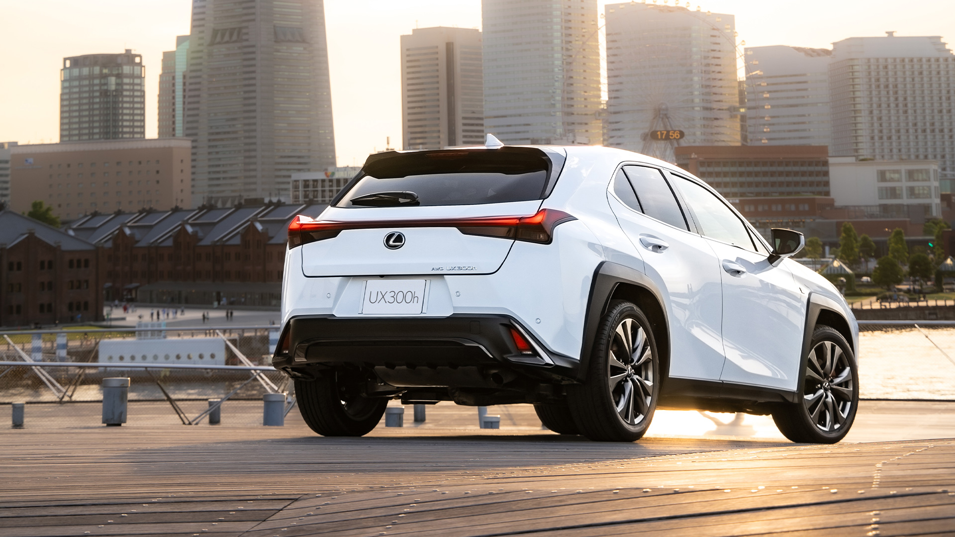 White Lexus UX in front of an urban sunset