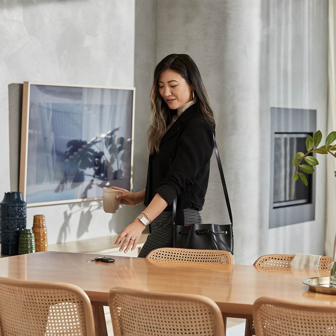 Business woman picking up her keys from the kitchen table as she heads out to work