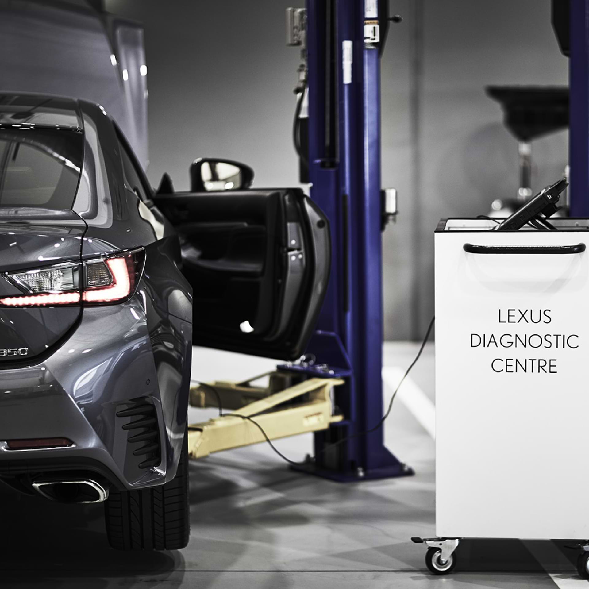 A Lexus sits in the Lexus diagnostic centre. A tool trolley is on the right.