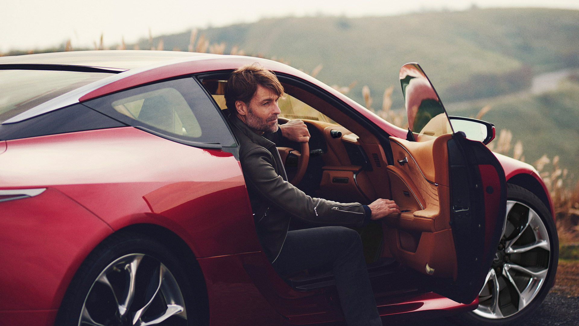 A man gets out of his parked Lexus.