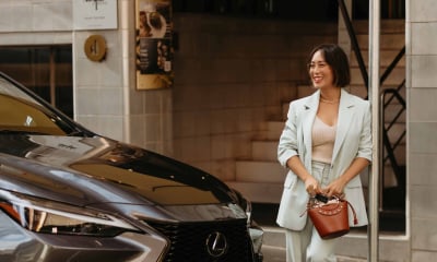 Lexus Ambassadors Lexus Brand Ambassador Melissa Leong stands beside dark grey Lexus LX SUV on a city street.