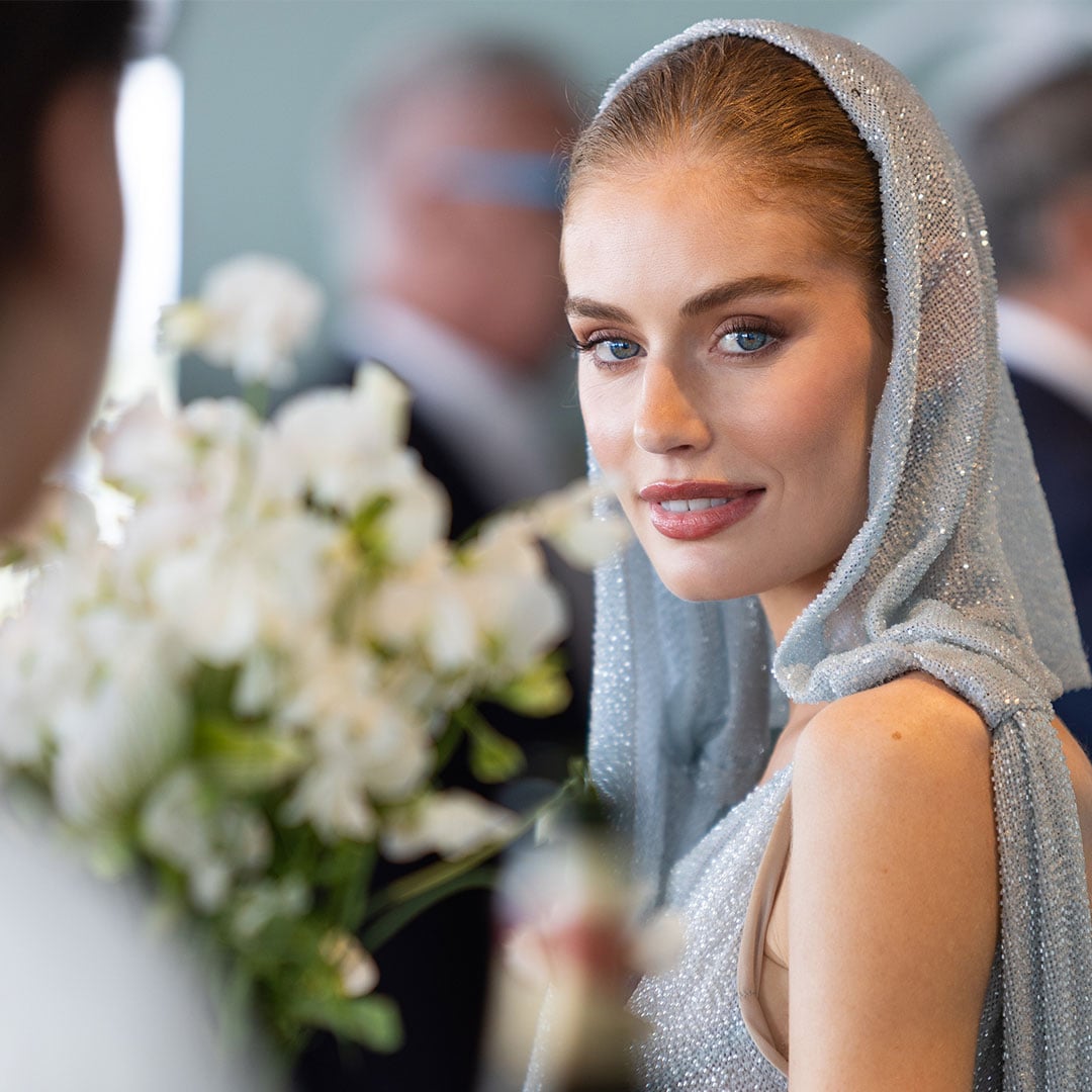 A stylish woman in a shimmering blue hooded dress at the Lexus Melbourne Cup event.